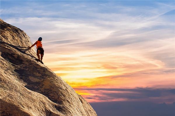 What is the meaning and symbol of climbing a rock wall in a dream?