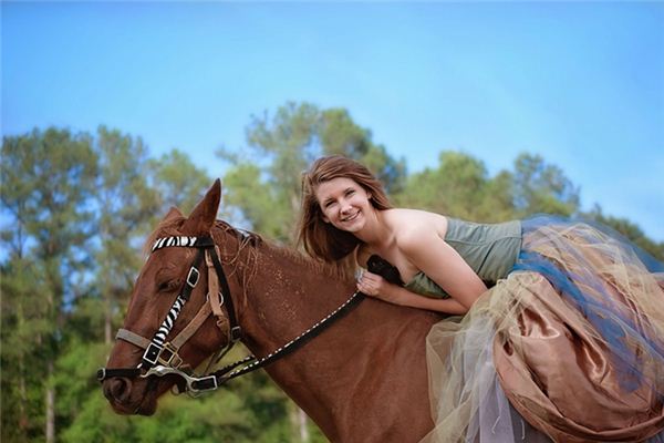 What is the meaning and symbol of a woman riding a horse in a dream?